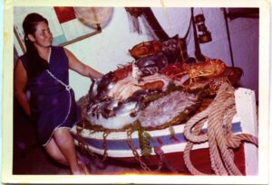 Ana Mari junto a la media barca. Fijaros en el tamaño de la langosta roja.